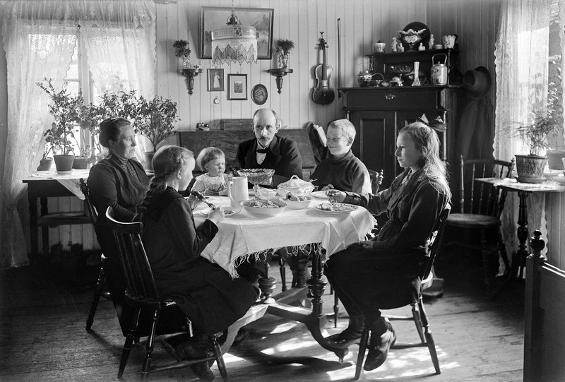 Med selvutløser har fotografen  foreviget seg selv, kona og barna i deres egen stue i hjemmet deres på Hollenderbjerget i Moss, ca. 1920.