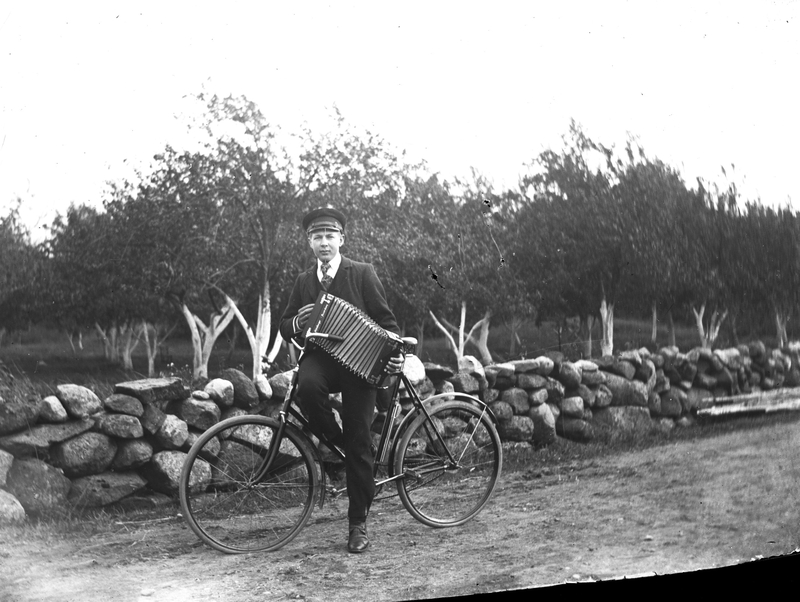 Nils från Jannes i Sällstorp med cykel och durspel vid Ahlbergs trädgård ca 1915.