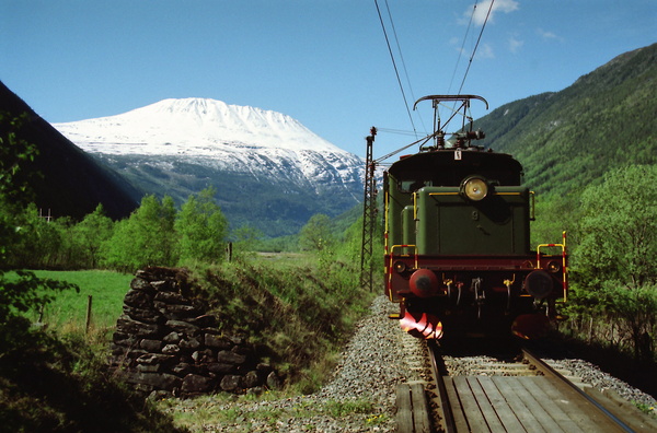 Lok nr 9 ved vindvollen på Miland våren 1990. Lokomotiv med snødekket Gaustatoppen i bakgrunnen.