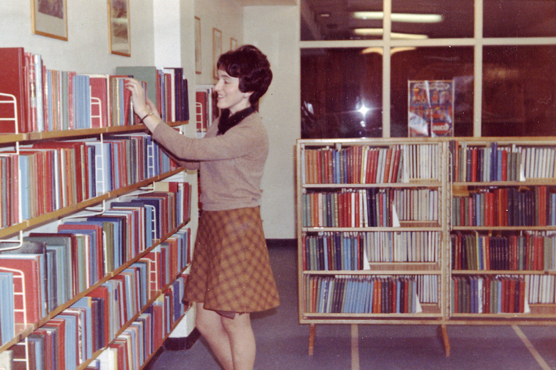 Bibliotekar Lina Jordal ved bokhylla på Odda bibliotek.