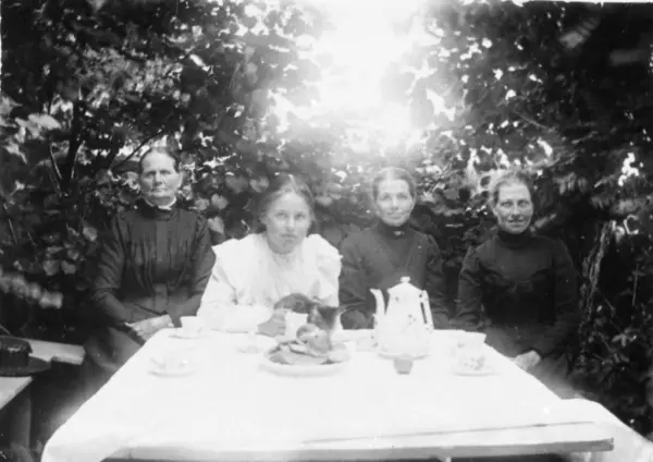 I bersån på Olas gård kring år 1905. Från vänster sitter Maria Eriksson, Valdeborg Johansson med en katt i famnen, Josefina Eriksson och pigan Anna Carlsson. Kållereds hembygdsförening.
