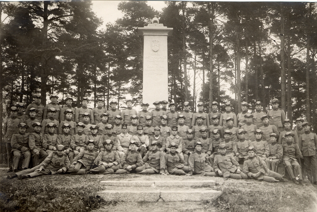 Gruppfoto av Västmanlands regemente I 18 framför monument över ...